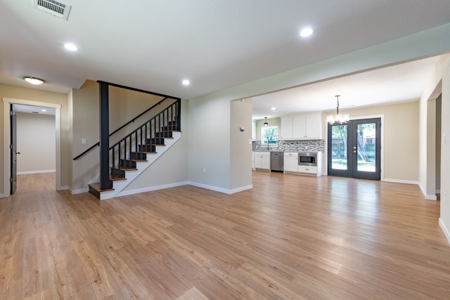 unfurnished living room with french doors and light hardwood / wood-style floors