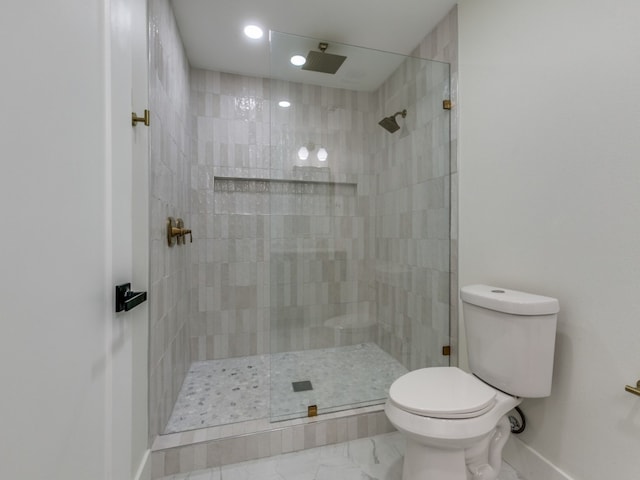 bathroom featuring toilet and a tile shower