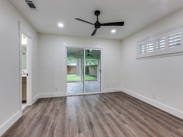 spare room with dark hardwood / wood-style flooring and ceiling fan