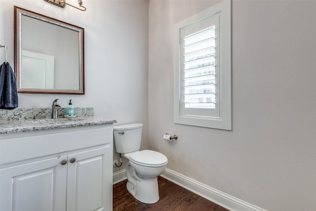 bathroom with toilet, hardwood / wood-style floors, and vanity