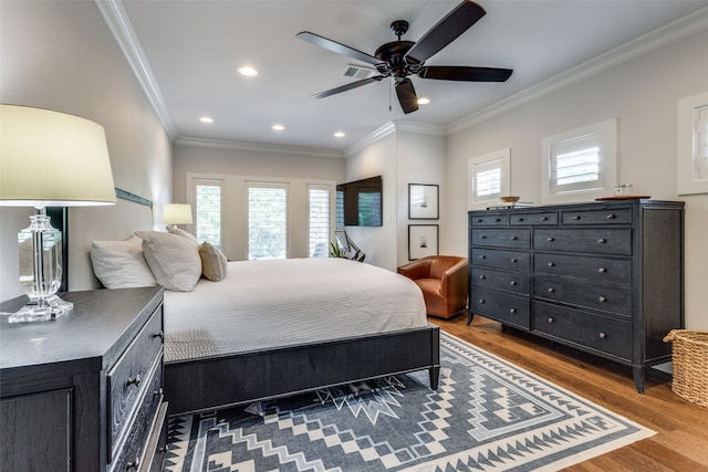 bedroom featuring crown molding, multiple windows, hardwood / wood-style floors, and ceiling fan