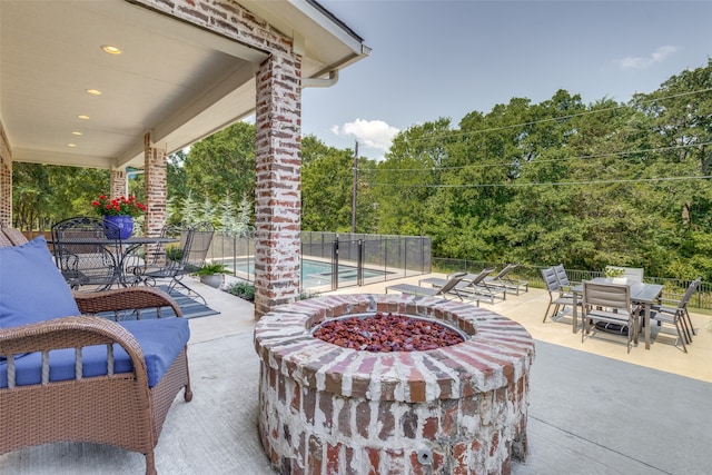 view of patio featuring an outdoor fire pit and a fenced in pool