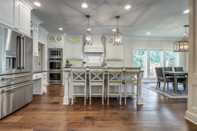 kitchen with white cabinetry, a breakfast bar area, dark hardwood / wood-style floors, custom exhaust hood, and appliances with stainless steel finishes