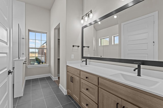 bathroom with walk in shower, tile patterned floors, plenty of natural light, and vanity