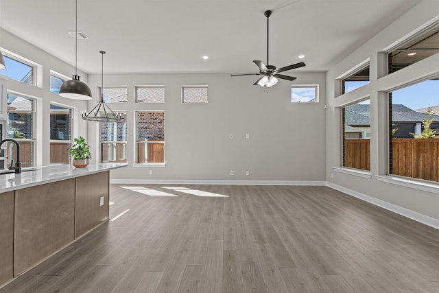 interior space with sink, ceiling fan, and light wood-type flooring