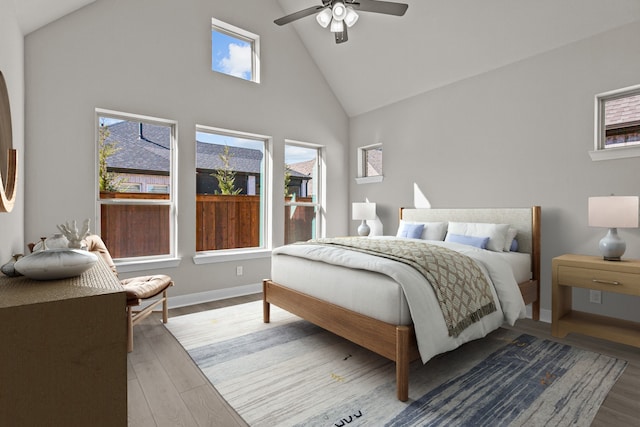 bedroom with wood-type flooring, high vaulted ceiling, and ceiling fan