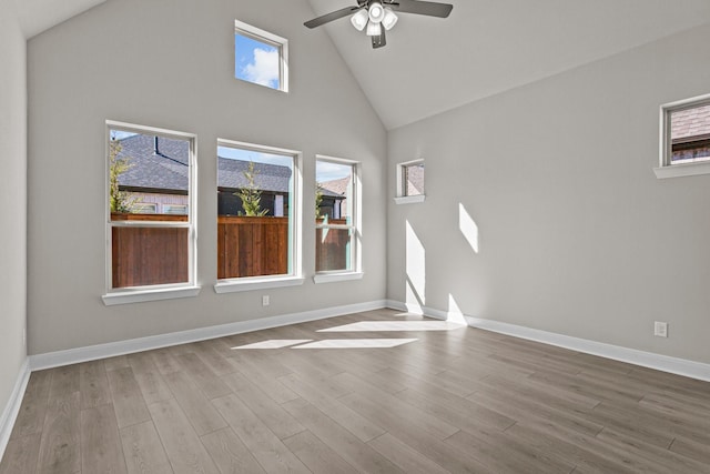 empty room featuring ceiling fan, high vaulted ceiling, and light hardwood / wood-style floors