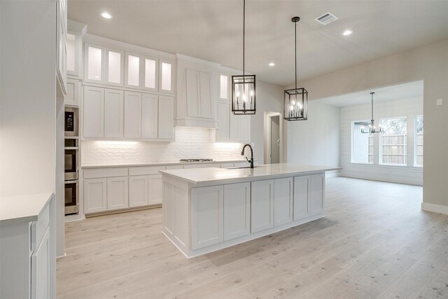 kitchen featuring white cabinetry, sink, a center island with sink, and appliances with stainless steel finishes