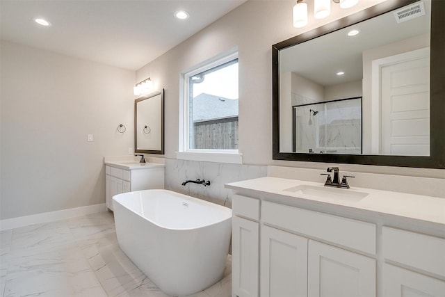 bathroom with vanity and shower with separate bathtub