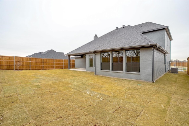 rear view of property featuring a patio area and a lawn