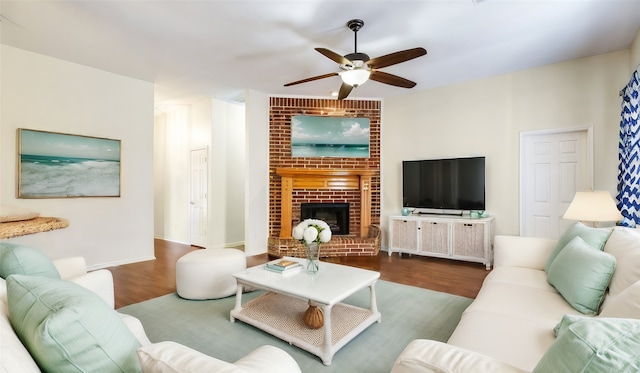 living room with brick wall, a fireplace, hardwood / wood-style floors, and ceiling fan