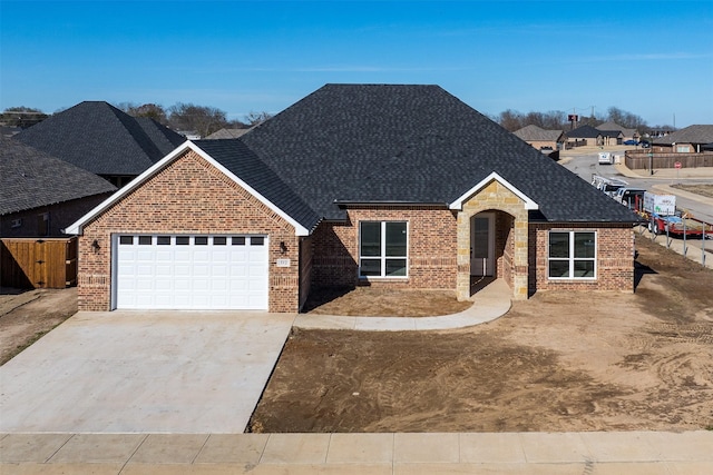 view of front facade with a garage, brick siding, driveway, and a shingled roof