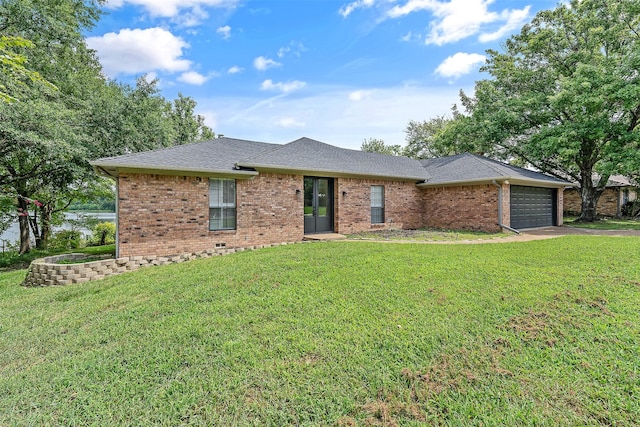 ranch-style house featuring a garage and a front lawn