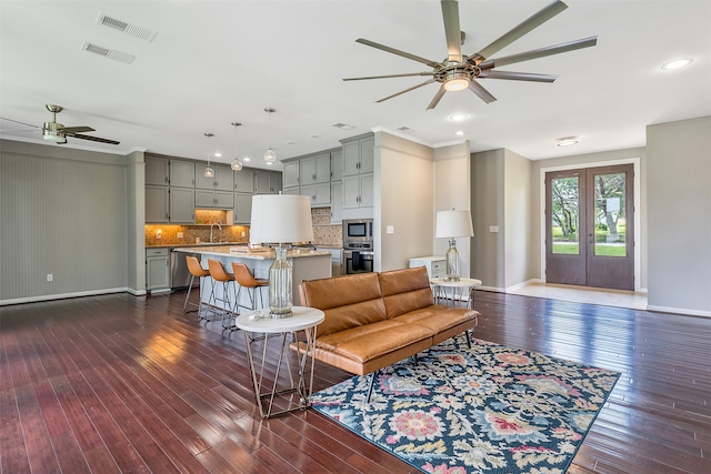 living room featuring sink, dark hardwood / wood-style flooring, ceiling fan, and french doors