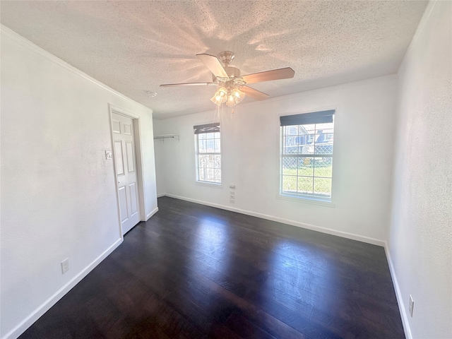 unfurnished room featuring a textured ceiling, ornamental molding, dark hardwood / wood-style floors, and ceiling fan