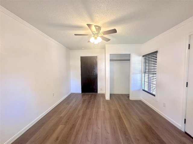 unfurnished bedroom with a textured ceiling, crown molding, dark hardwood / wood-style flooring, and ceiling fan