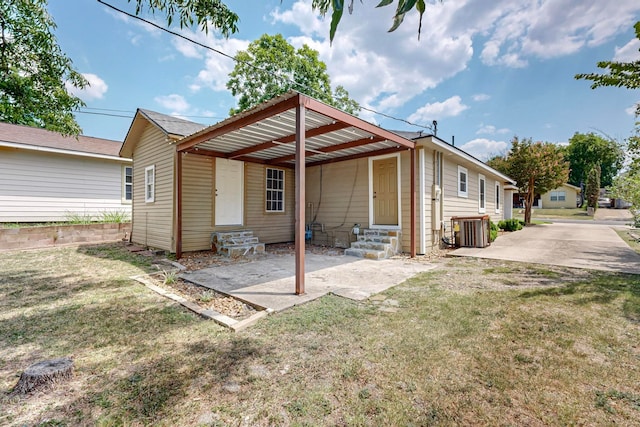 back of property featuring a lawn, central air condition unit, and a patio area