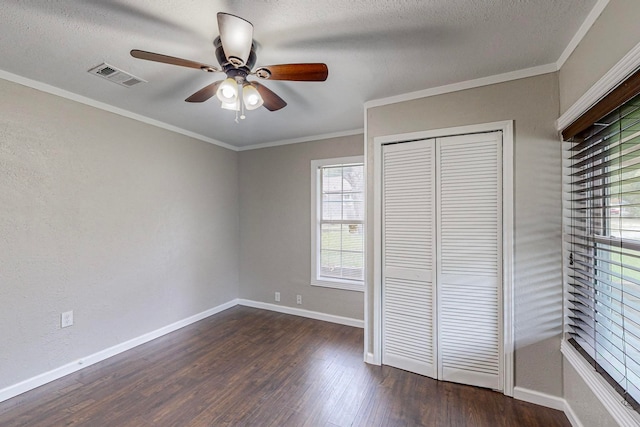 unfurnished bedroom with crown molding, dark hardwood / wood-style floors, ceiling fan, and a closet