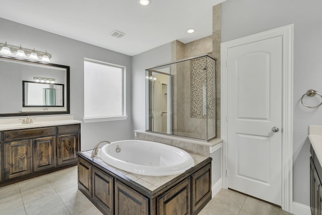 bathroom featuring independent shower and bath, vanity, and tile patterned flooring