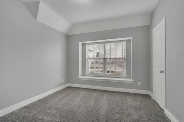 unfurnished room featuring lofted ceiling and carpet floors