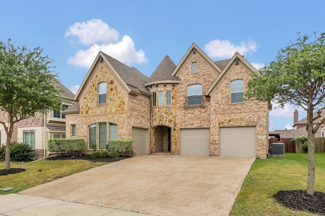 view of front of home featuring cooling unit, a garage, and a front yard