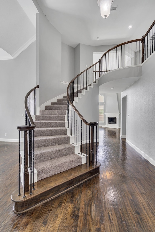 stairs featuring hardwood / wood-style flooring and a high ceiling