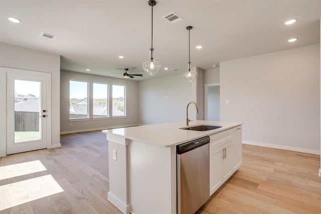 kitchen featuring stainless steel dishwasher, sink, white cabinetry, and a center island with sink