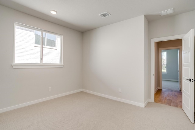 carpeted spare room featuring plenty of natural light