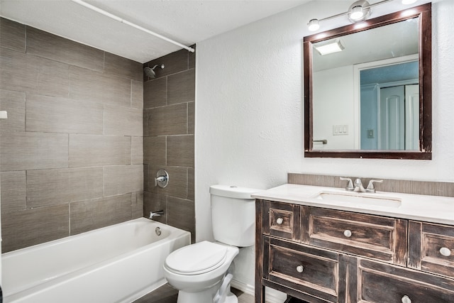 full bathroom with vanity, tiled shower / bath combo, toilet, and a textured ceiling