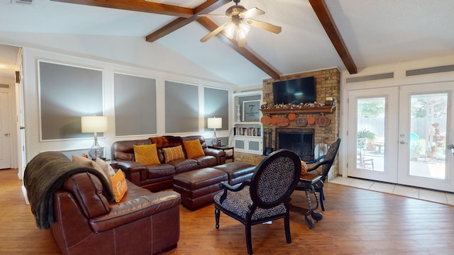 living room featuring lofted ceiling with beams, light hardwood / wood-style flooring, a fireplace, brick wall, and ceiling fan