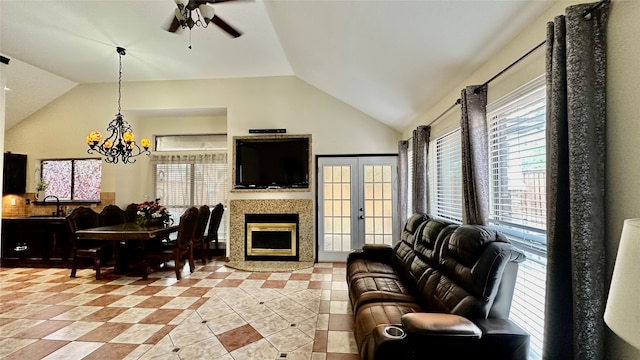 tiled living room featuring french doors, ceiling fan with notable chandelier, a healthy amount of sunlight, and lofted ceiling