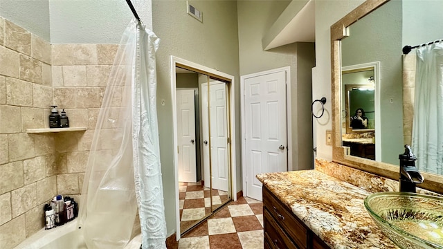 bathroom with vanity, a textured ceiling, and tile patterned flooring