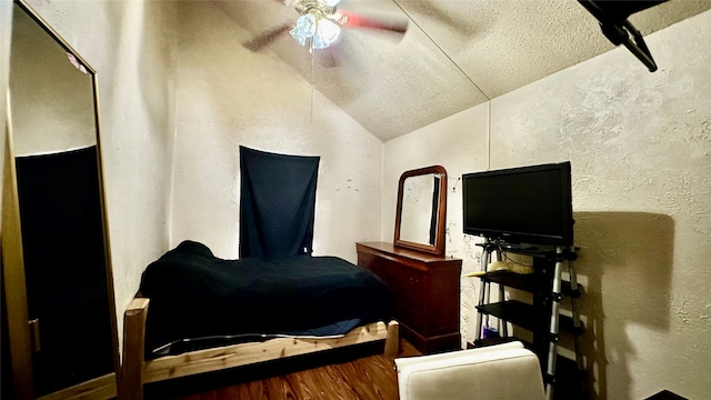 bedroom with ceiling fan, a textured ceiling, and vaulted ceiling