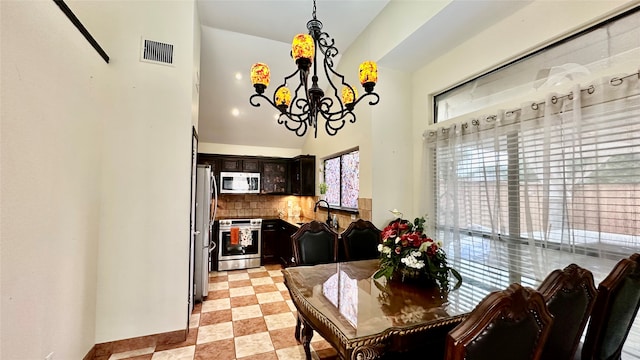 dining room with light tile patterned floors, sink, and an inviting chandelier