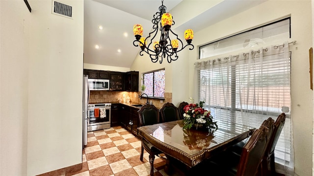 tiled dining space featuring high vaulted ceiling, sink, and an inviting chandelier