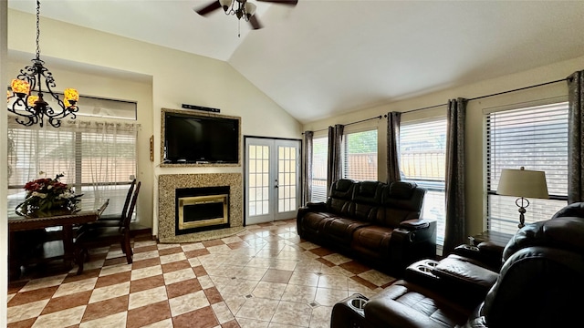 living room featuring ceiling fan with notable chandelier, light tile patterned floors, and lofted ceiling