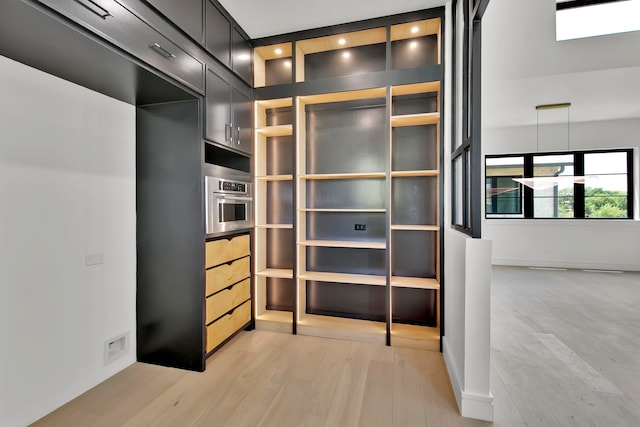 walk in closet with light hardwood / wood-style floors