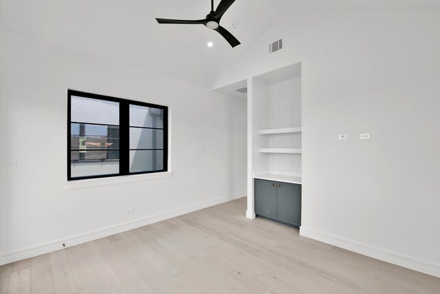 unfurnished room with built in shelves, lofted ceiling, ceiling fan, and light hardwood / wood-style floors