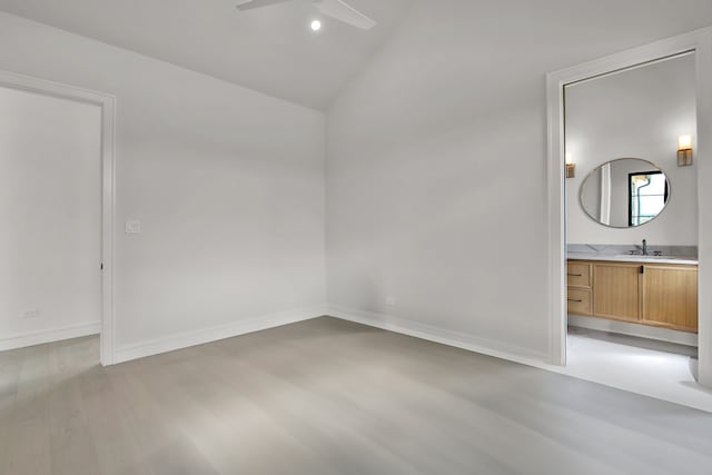 unfurnished bedroom featuring light hardwood / wood-style floors, lofted ceiling, ceiling fan, and sink