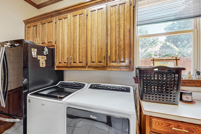 washroom with cabinets, ornamental molding, and washer and clothes dryer