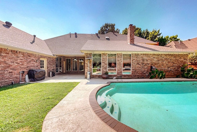 view of pool with a patio area and a lawn