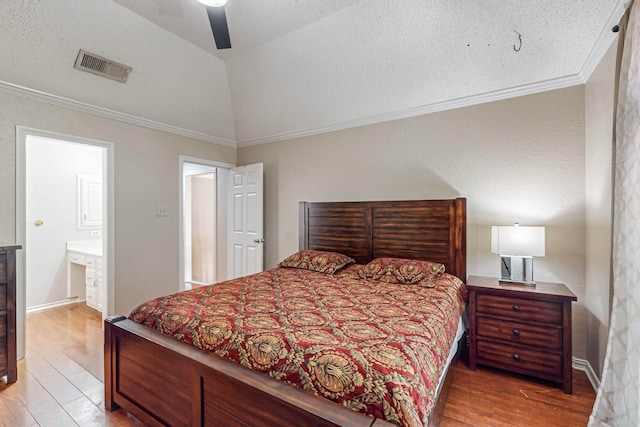 bedroom featuring light hardwood / wood-style flooring, connected bathroom, vaulted ceiling, and ceiling fan