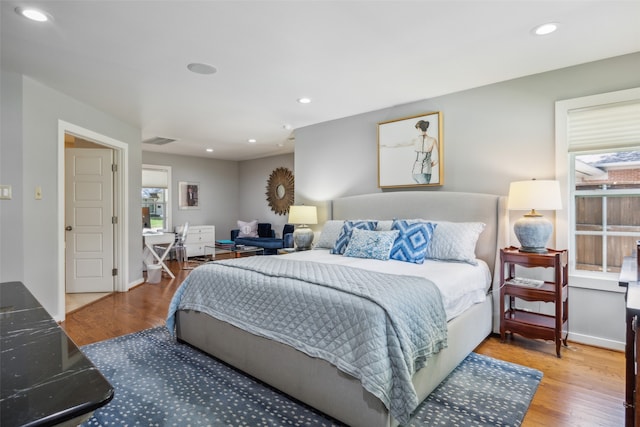 bedroom with multiple windows and wood-type flooring