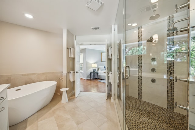 bathroom with vanity, shower with separate bathtub, wood-type flooring, and tile walls