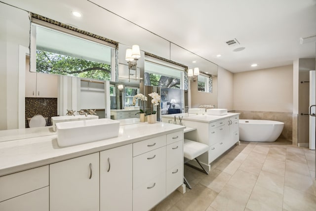 5332 Edmondson Ave, Dallas, TX 75209 - bathroom featuring a freestanding tub, two vanities, recessed lighting, and tile patterned floors