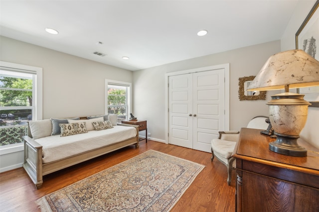 bedroom featuring a closet, multiple windows, and hardwood / wood-style floors