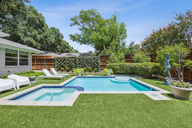 view of swimming pool featuring an in ground hot tub and a yard