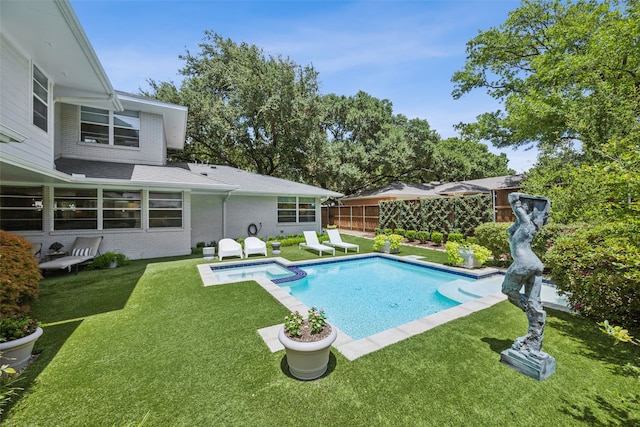 view of swimming pool with an in ground hot tub and a lawn