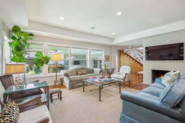 living room with a healthy amount of sunlight, a raised ceiling, and wood-type flooring