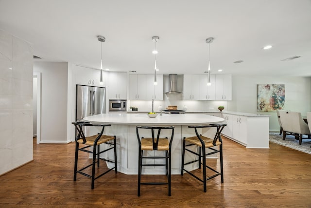 5332 Edmondson Ave, Dallas, TX 75209 - kitchen with wall chimney range hood, stainless steel appliances, a kitchen island with sink, light countertops, and white cabinetry